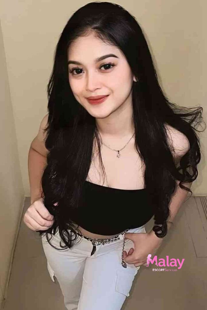 Malay Escort Service Young woman with long black hair wearing a black crop top and white pants KL Escort Girl