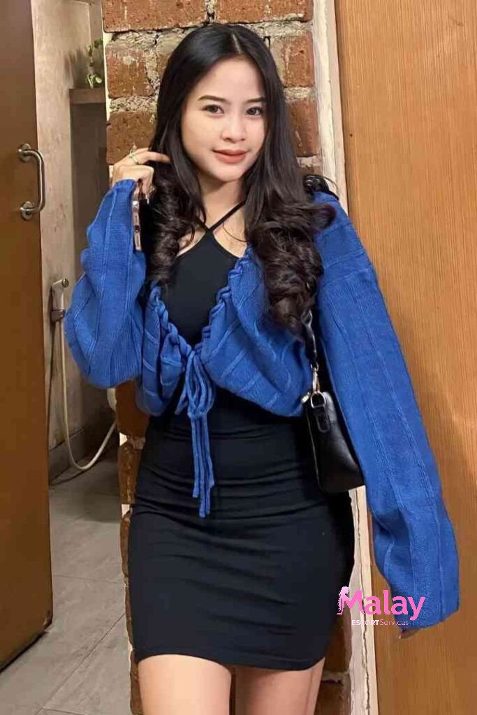 Malay Escort Service Young woman in a black dress and blue shrug poses for a photo KL Escort Girl Malay Escort KL Real KL Escorts Ready for You Malay Escort Service Young woman in a black dress and blue shrug poses for a photo KL Escort Girl