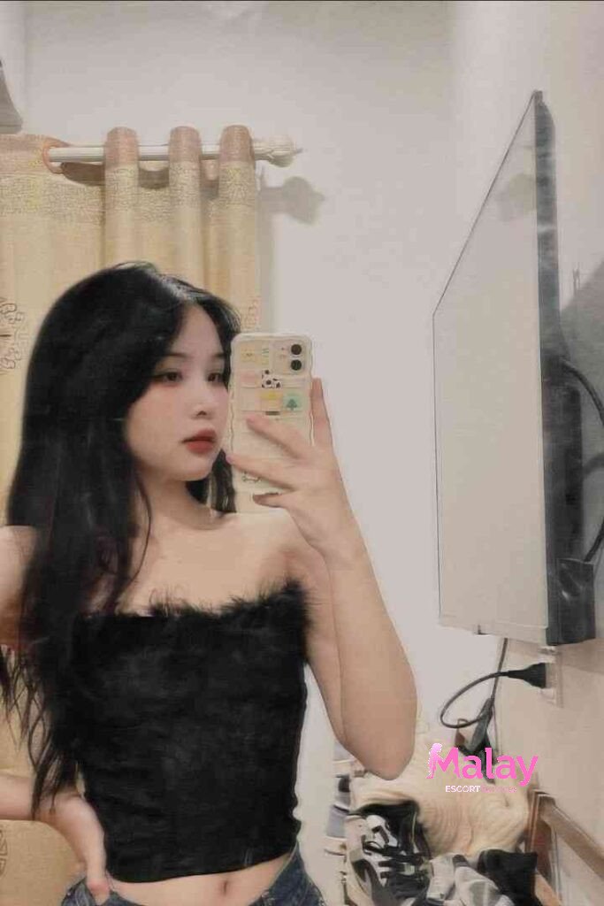 Malay Escort Service Young woman in a black fuzzy tube top taking a mirror selfie with her phone KL Escort Girl Malay Escort KL Real KL Escorts Ready for You Malay Escort Service Young woman in a black fuzzy tube top taking a mirror selfie with her phone KL Escort Girl