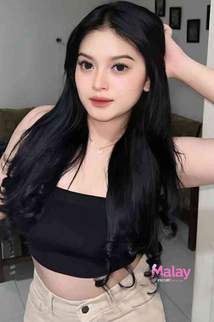 Malay Escort Service Young woman with long black hair wearing a black crop top and beige pants KL Escort Girl