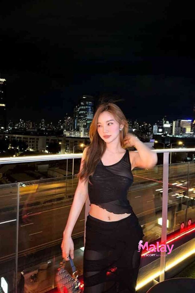 Malay Escort Service Woman in black mesh top and skirt on rooftop at night with city skyline KL Escort Girl Malay Escort KL Real KL Escorts Ready for You Malay Escort Service Woman in black mesh top and skirt on rooftop at night with city skyline KL Escort Girl