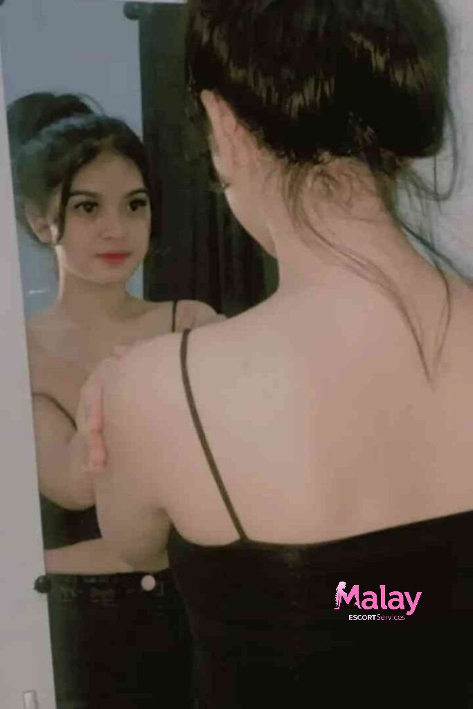Malay Escort Service Woman in black top looking in mirror KL Escort Girl
