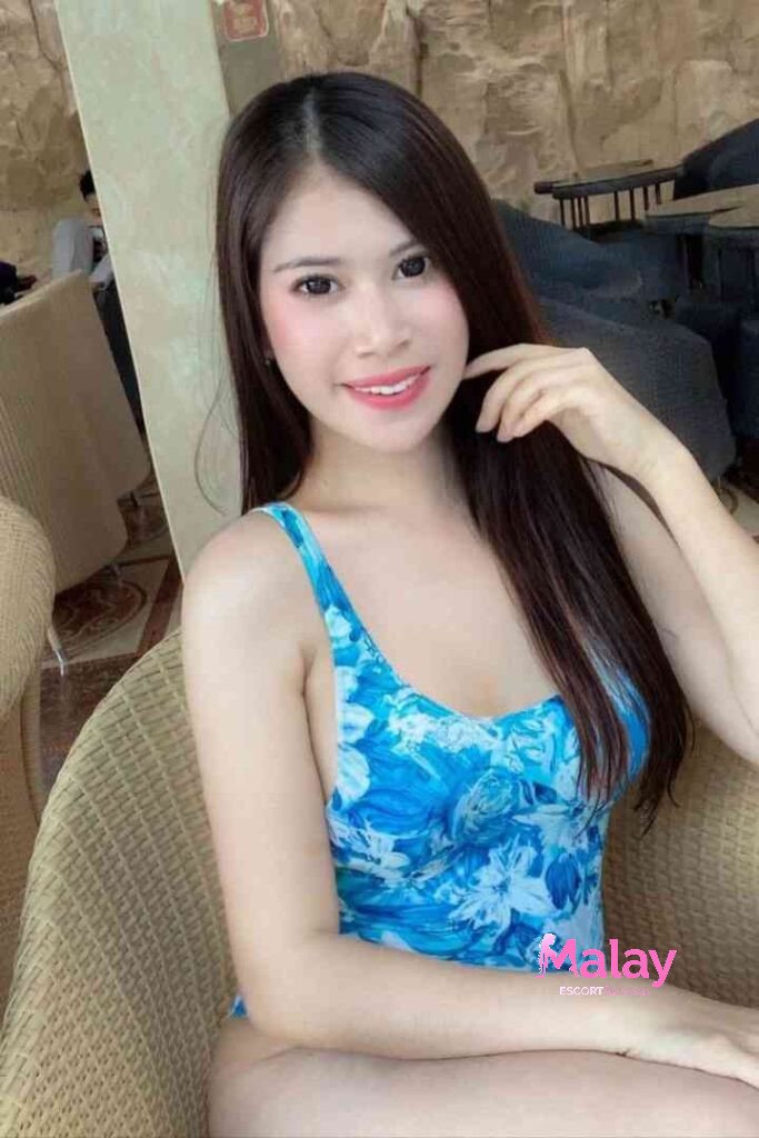 Malay Escort Service Young woman in a blue floral swimsuit smiling KL Escort Girl
