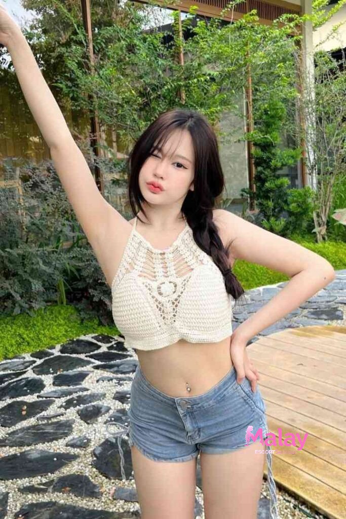 Malay Escort Service Young woman in a white crochet top and denim shorts posing outdoors KL Escort Girl Malay Escort KL Real KL Escorts Ready for You Malay Escort Service Young woman in a white crochet top and denim shorts posing outdoors KL Escort Girl