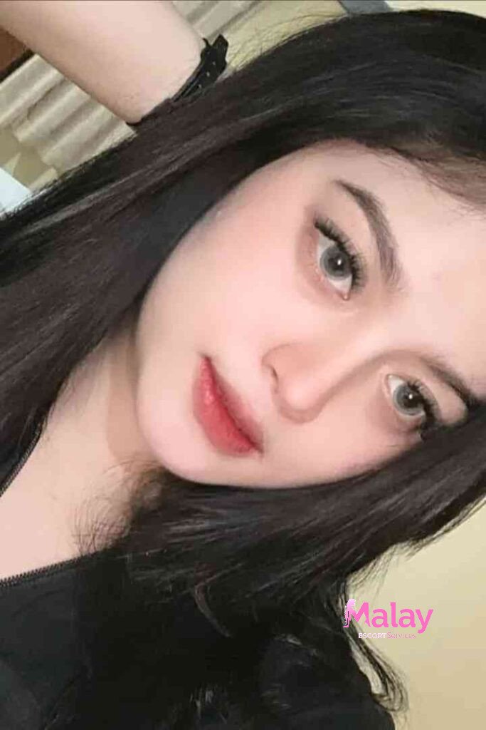 Malay Escort Service Close up of a young woman with dark hair and striking grey eyes wearing subtle makeup KL Escort Girl