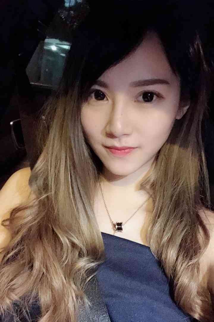 Malay Escort Service Young woman with long ombre hair and a dark top, wearing a necklace. KL Escort Girl