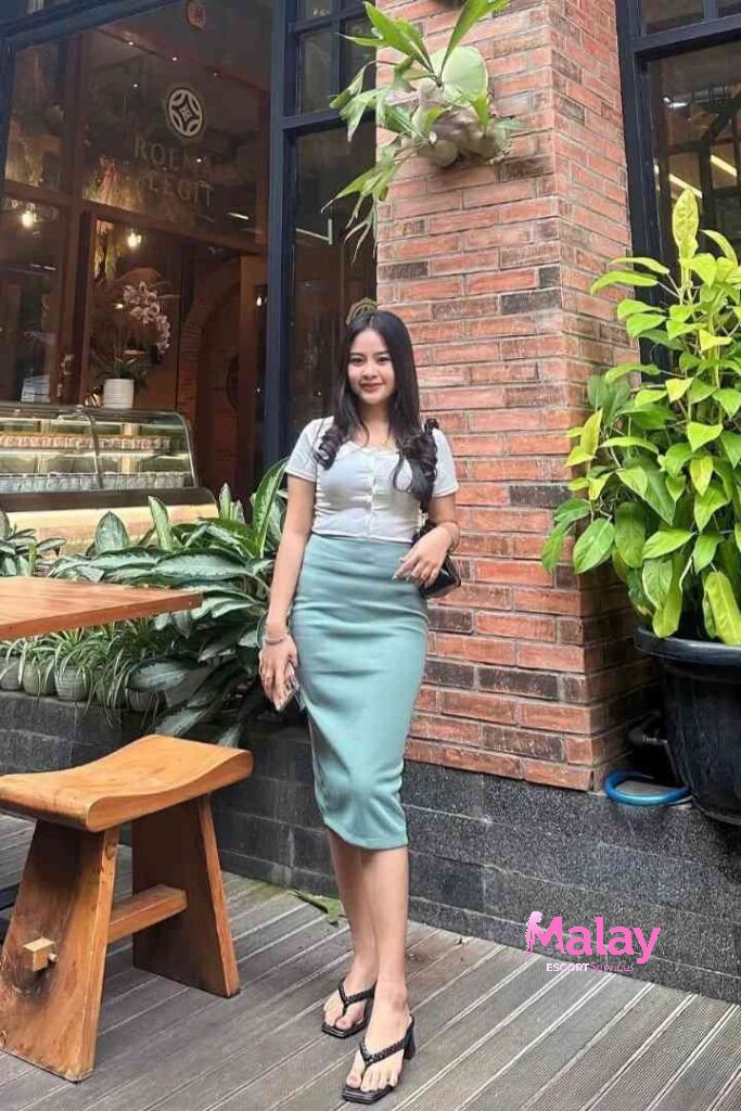 Malay Escort Service Young woman in a light blue skirt and white top at an outdoor cafe KL Escort Girl Malay Escort KL Real KL Escorts Ready for You Malay Escort Service Young woman in a light blue skirt and white top at an outdoor cafe KL Escort Girl