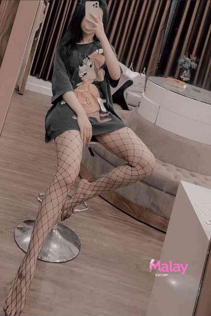 Malay Escort Service Woman in oversized tshirt and fishnet stockings sitting on a stool KL Escort Girl Malay Escort KL Real KL Escorts Ready for You Malay Escort Service Woman in oversized t shirt and fishnet stockings sitting on a stool KL Escort Girl
