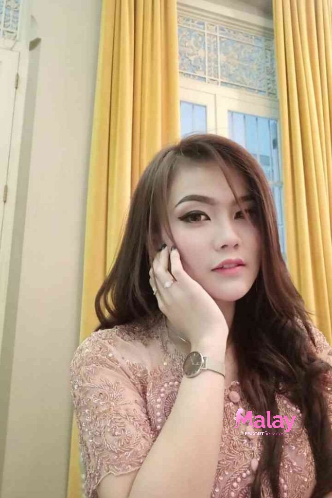 Malay Escort Service Woman in a pink lace dress with a watch on her wrist KL Escort Girl