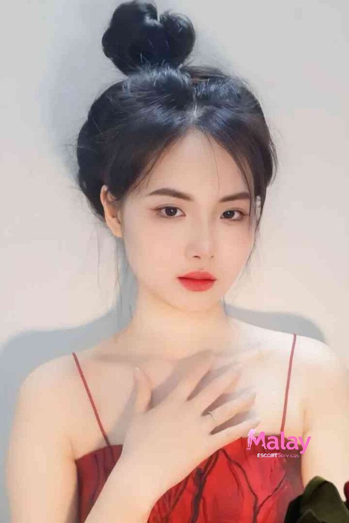 Malay Escort Service Young woman with dark hair in a bun wearing a red spaghetti strap dress with her hand on her chest KL Escort Girl Malay Escort KL Real KL Escorts Ready for You Malay Escort Service Young woman with dark hair in a bun wearing a red spaghetti strap dress with her hand on her chest KL Escort Girl