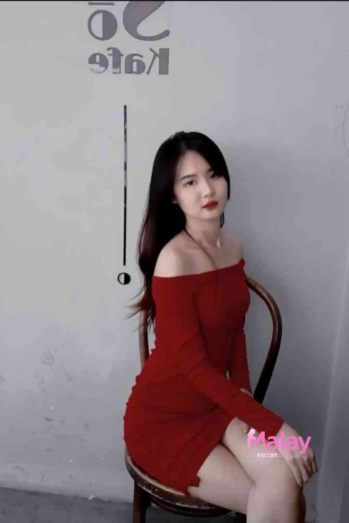 Malay Escort Service Young woman in red offtheshoulder dress sitting on a chair KL Escort Girl Malay Escort KL Real KL Escorts Ready for You Malay Escort Service Young woman in red off the shoulder dress sitting on a chair KL Escort Girl