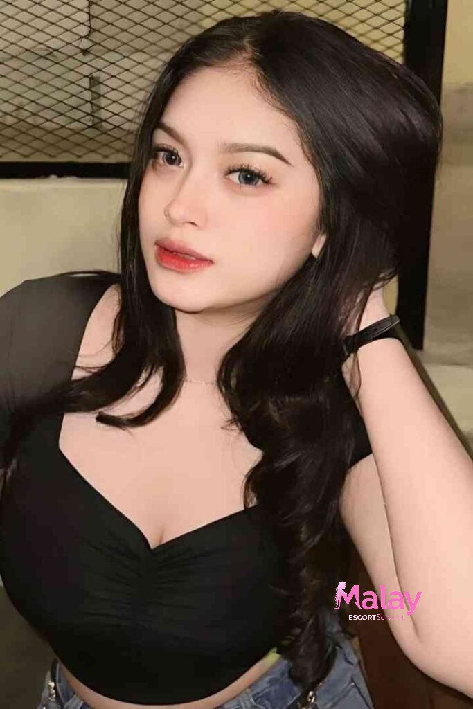 Malay Escort Service Young woman with dark hair and makeup wearing a black top KL Escort Girl