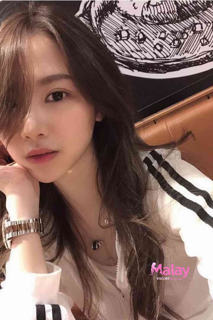 Malay Escort Service Young woman with long brown hair and a silver watch KL Escort Girl
