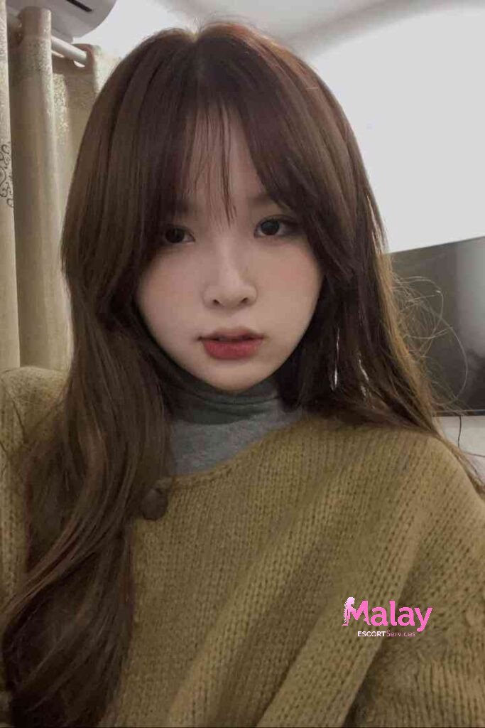 Malay Escort Service Young woman with long brown hair and bangs wearing a turtleneck and mustardcolored sweater KL Escort Girl Malay Escort KL Real KL Escorts Ready for You Malay Escort Service Young woman with long brown hair and bangs wearing a turtleneck and mustard colored sweater KL Escort Girl
