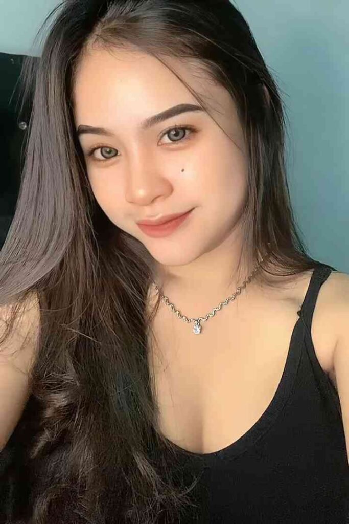 Malay Escort Service Young woman with long dark hair and a black tank top wearing a silver necklace KL Escort Girl