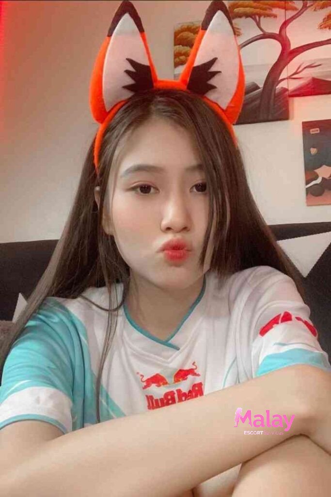 Malay Escort Service Young woman with fox ears headband pouts lips wearing a white and blue shirt KL Escort Girl Malay Escort KL Real KL Escorts Ready for You Malay Escort Service Young woman with fox ears headband pouts lips wearing a white and blue shirt KL Escort Girl