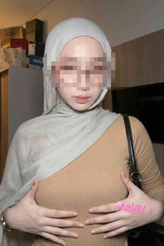 Malay Escort Service Woman in hijab and brown top holding her chest KL Escort Girl