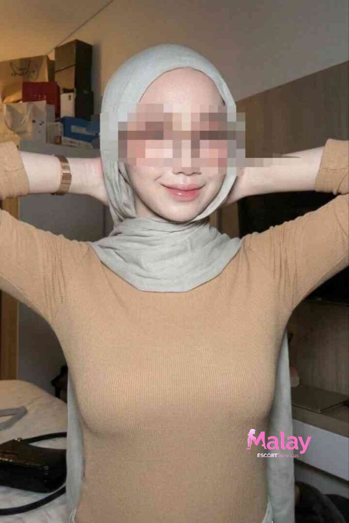 Malay Escort Service Woman in hijab and tan top smiling hands behind head KL Escort Girl